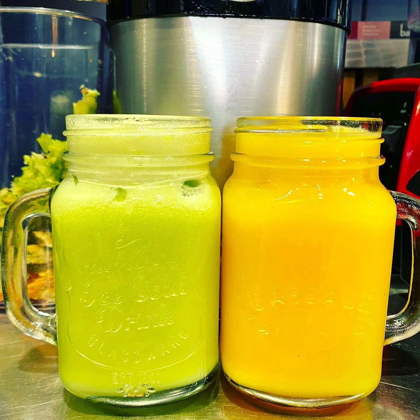 Fresh green and orange juices in jars